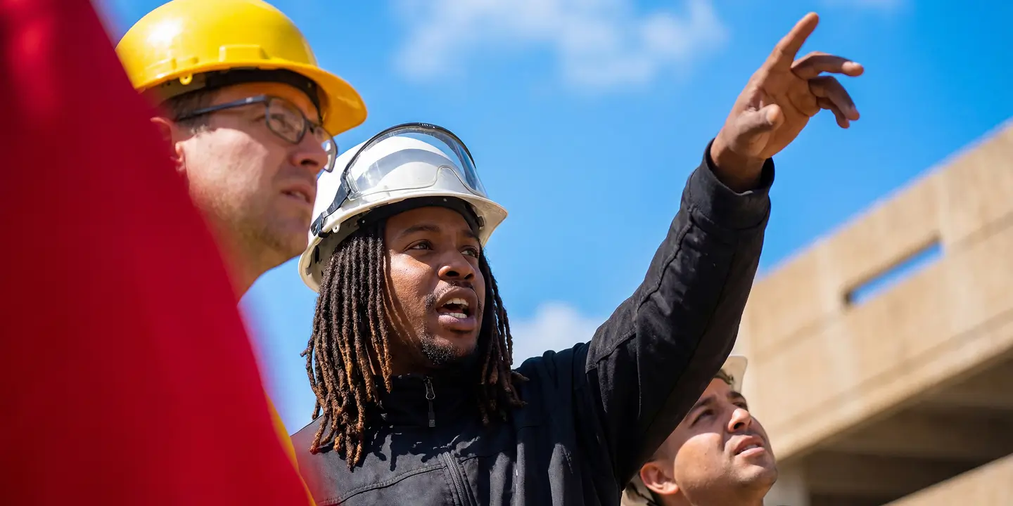 Workers investigating a worksite and pointing