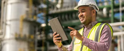 Man in a construction hat using an ipad